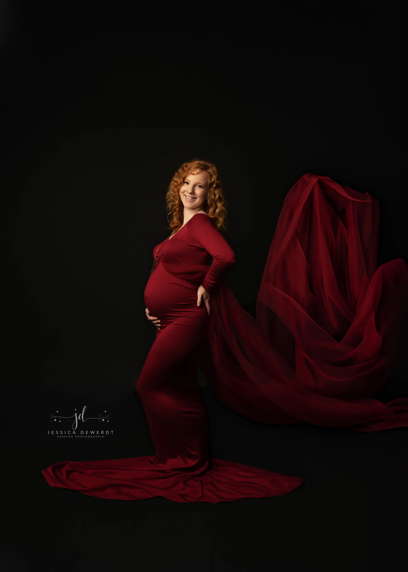Future maman en robe rouge sur fond noir
