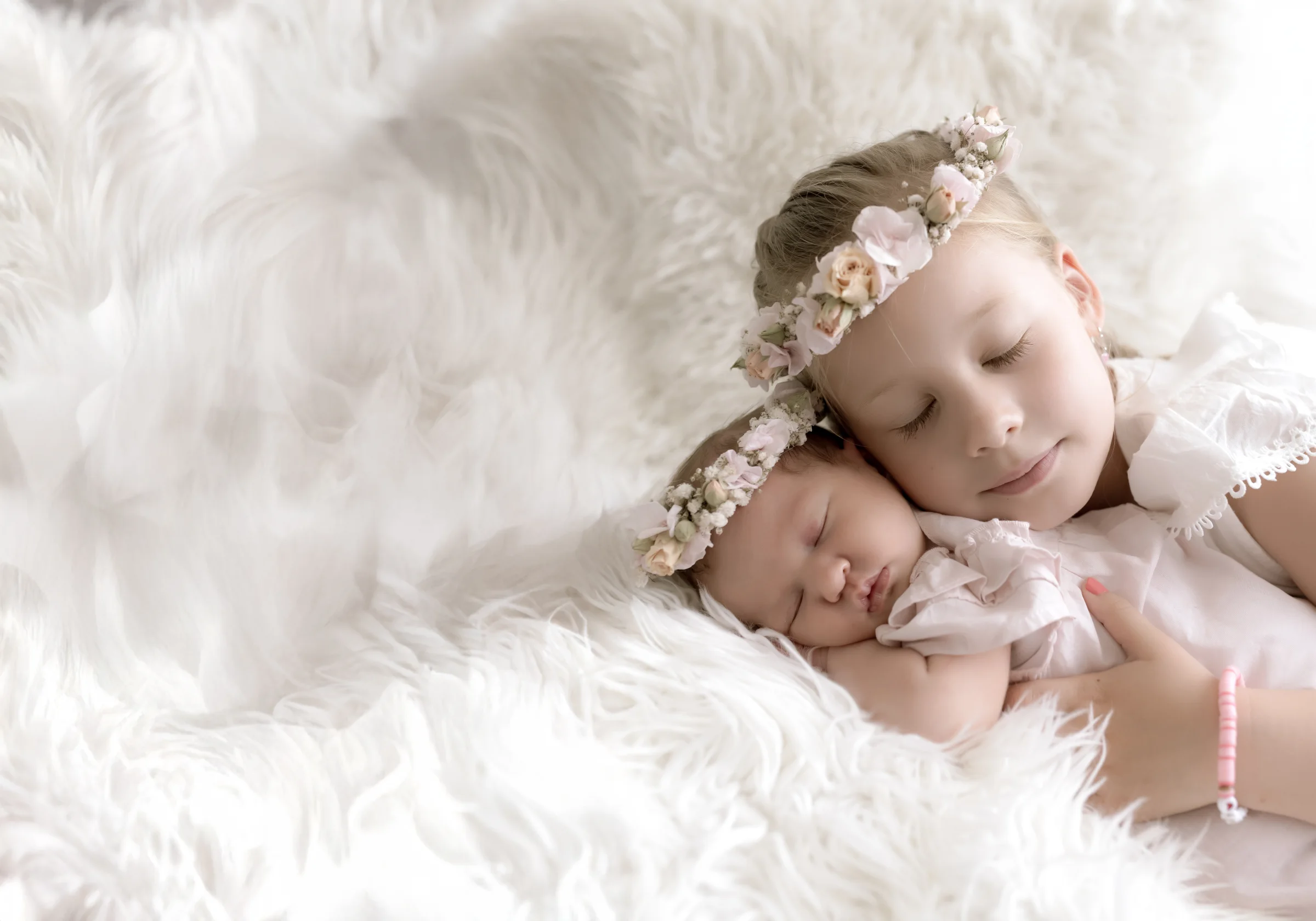 Deux enfants tendrement enlacés sur une couverture blanche